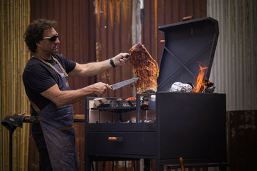 Argentine gaucho grill cooking steak over wood fire Ñuke Delta