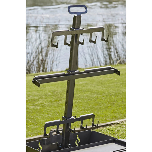 Metal fishing rod holder with multiple hooks on a grassy area by a body of water.
