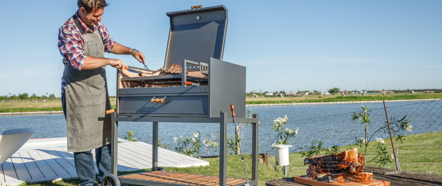 Man grilling outdoors by a lake with a scenic background